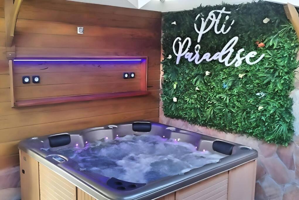 a hot plunge tub in a room with a sign at P'ti Paradise in Le Gosier