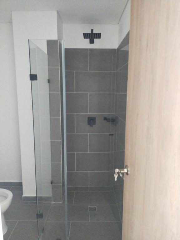 a shower with a glass door in a bathroom at Cataleya - Apartamentos in Marinilla