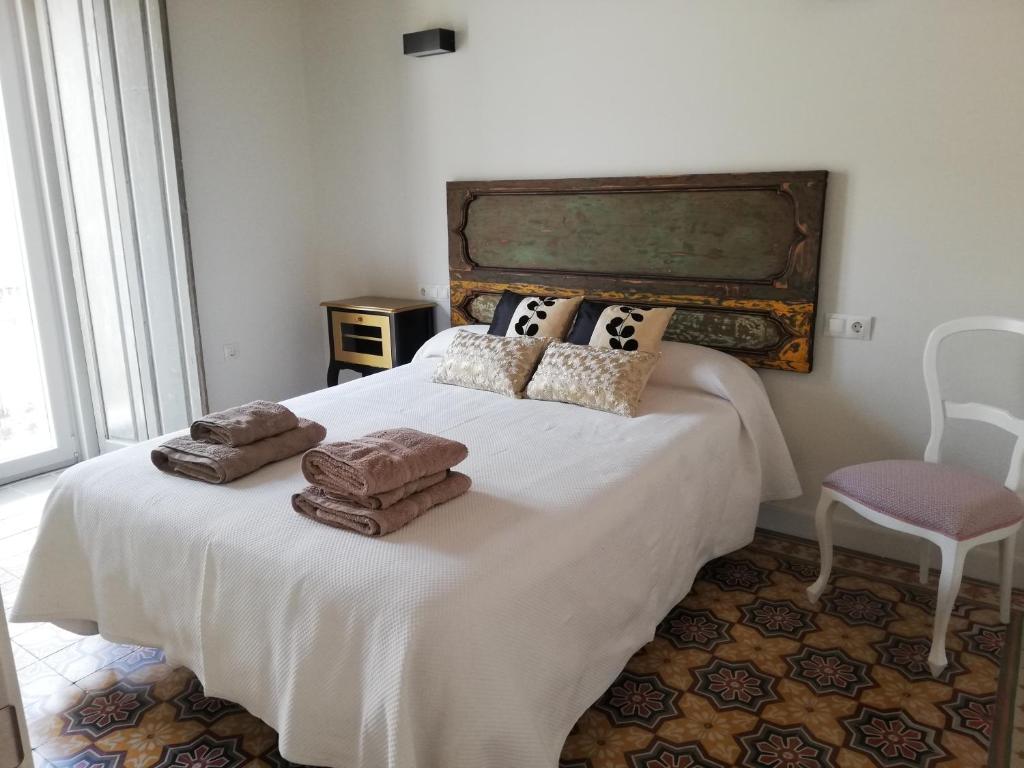 Un dormitorio con una cama blanca con toallas. en CASA PALACIO CABALLEROS 7 con Parking, en Sanlúcar de Barrameda