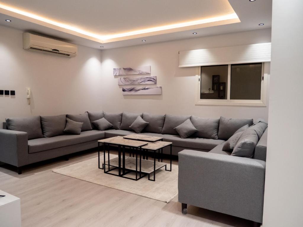 een woonkamer met een bank en een tafel bij Spacious apartments A in Riyad
