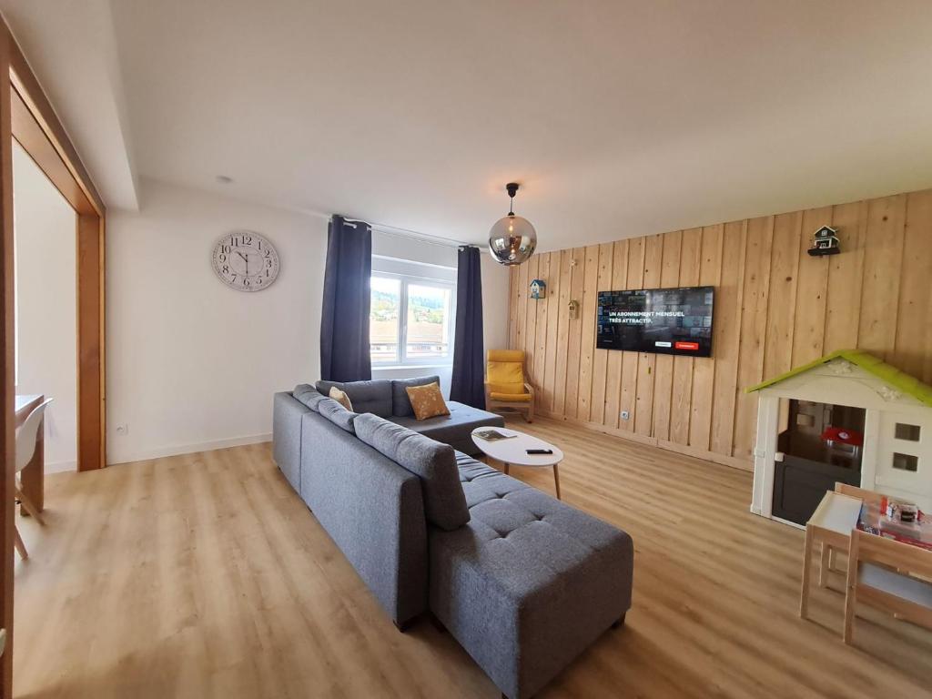 salon z kanapą i stołem w obiekcie Fête des jonquilles w mieście Gérardmer