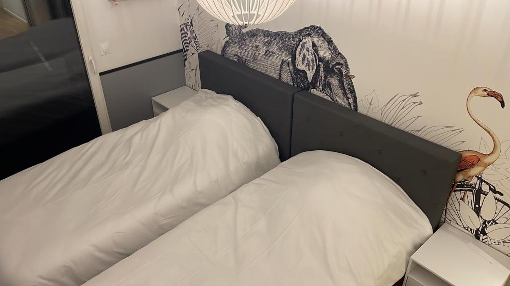 a bed with a white pillow on top of it at Appartement Luxueux 3 pièces climatisé avec Terrasse, 5 couchages - 17ème Arrondissement de Paris in Clichy