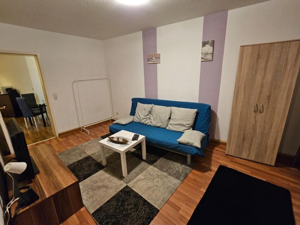 - un salon avec un canapé bleu et une table dans l'établissement Altstadtapartment, à Nordhausen