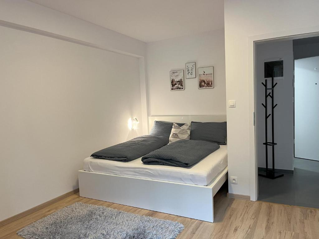 een witte slaapkamer met een bed in een kamer bij Apartmán NeKLID in Jáchymov