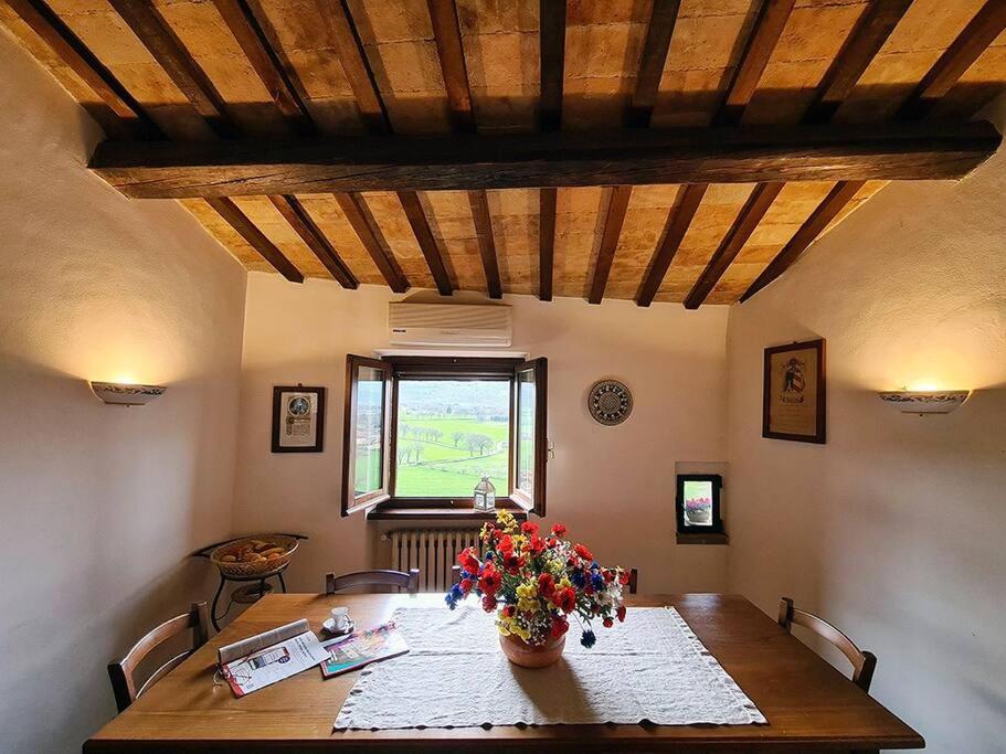 uma mesa de jantar com um vaso de flores em La casa di MonAmì em Spello