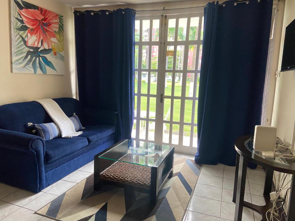 奧喬里奧斯的住宿－Firefly at Sandcastle，客厅配有蓝色的沙发和玻璃桌