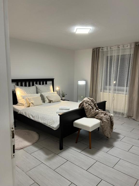 a bedroom with a large bed and a chair at Holiday Homes 1 in Monzingen