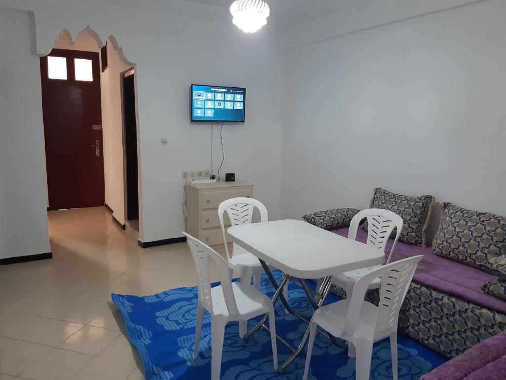 a living room with a couch and a table and chairs at Family House in Agadir