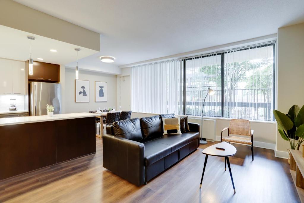 a living room with a couch and a kitchen at Great Condo for a Comfortable Stay @Crystal City in Arlington