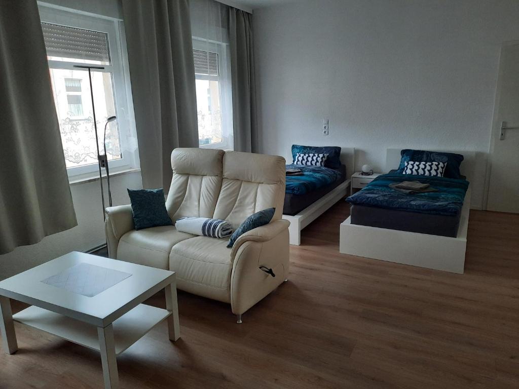 - un salon avec un canapé et une table dans l'établissement Apartments Wagner, à Crimmitschau