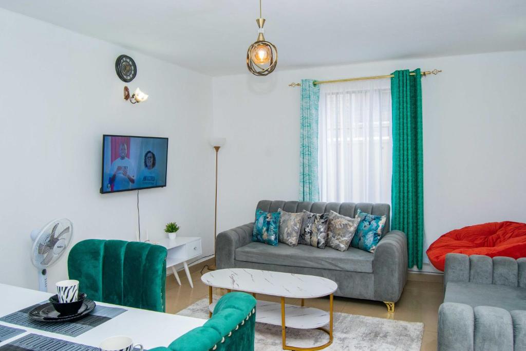 un soggiorno con divano e tavolo di Tina's 1 BR Apartment with Fast Wi-Fi, Parking and Netflix - Kisumu a Kisumu