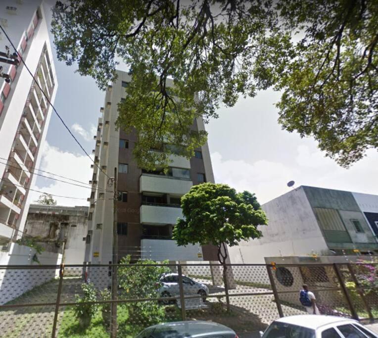 a building with cars parked in front of it at Completo com Ar-condicionado in Recife
