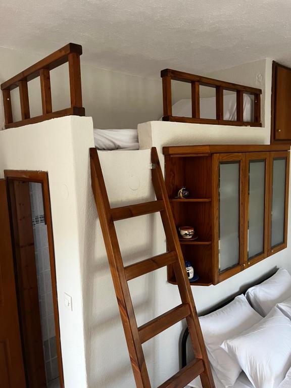two bunk beds in a room with a ladder at Chris & Mary Comfort Rooms (country house) in Nea Iraklia