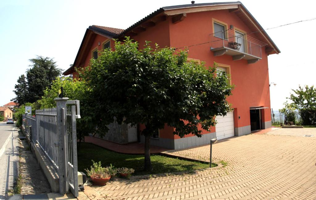 ein orangenes Haus mit einem Baum davor in der Unterkunft B&B Alba in Langhe in Verduno