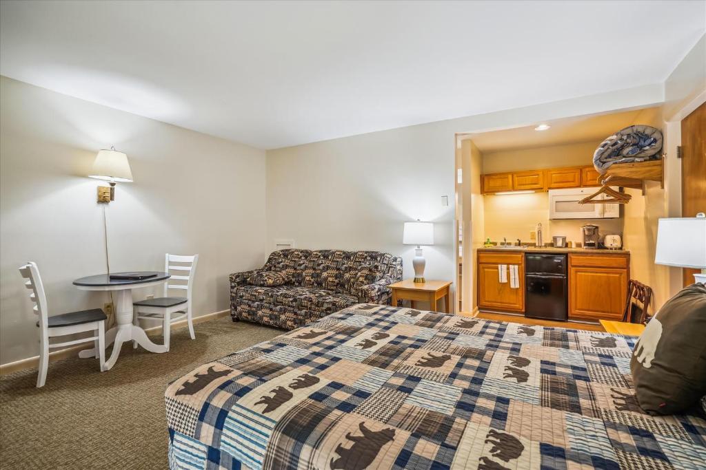 um quarto de hotel com uma cama e uma cozinha em Cedarbrook Queen Studio 110 em Killington