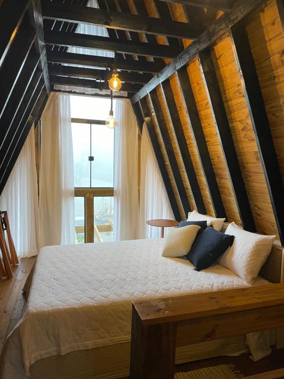 uma cama num quarto com uma grande janela em Portal Dos Campos em Ponta Grossa