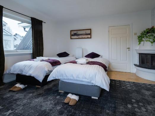 a bedroom with two twin beds and a fireplace at Aurora Dream House Apartment with free parking in Tromsø