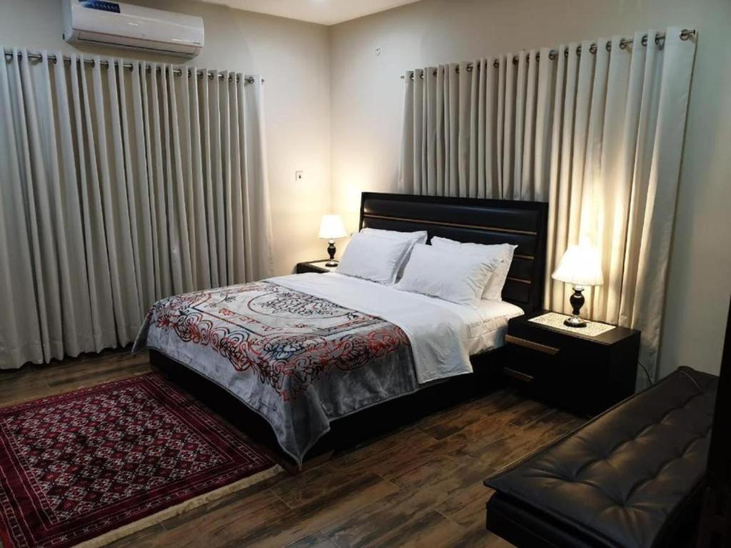 1 dormitorio con 1 cama grande y 1 sofá en Islamabad Layover Guest House Free Airport Pick and Drop, en Islamabad