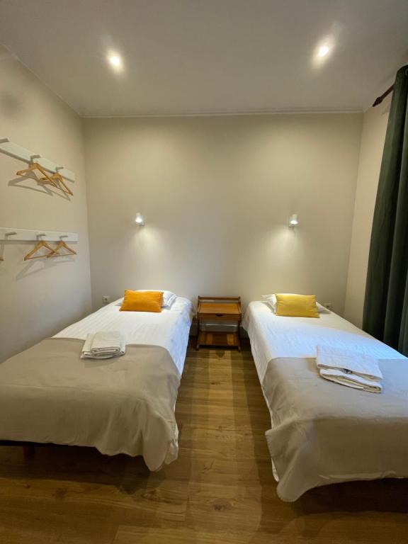 two twin beds in a room with at Quartos privados - Quinta da Paz in Santa Cruz