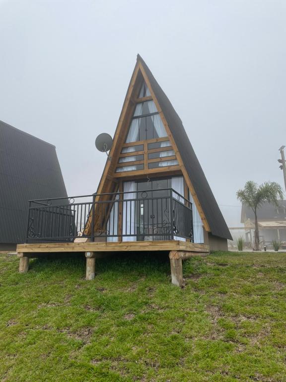 uma casa com um telhado de gambrel com um deque em Pousada Portal dos campos em Ponta Grossa