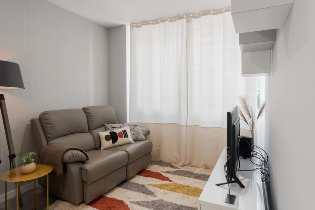 a living room with a couch and a tv at Great Location Very Central Boavista in Porto