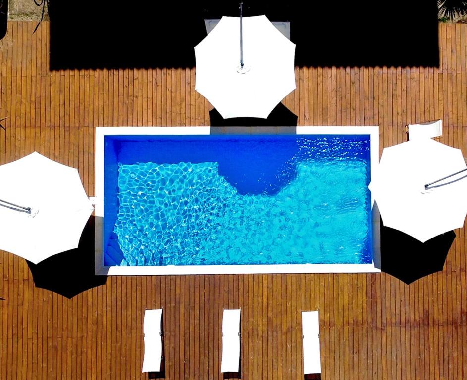 una imagen de una piscina de agua con sombrillas en Hotel Milano, en Punta del Este