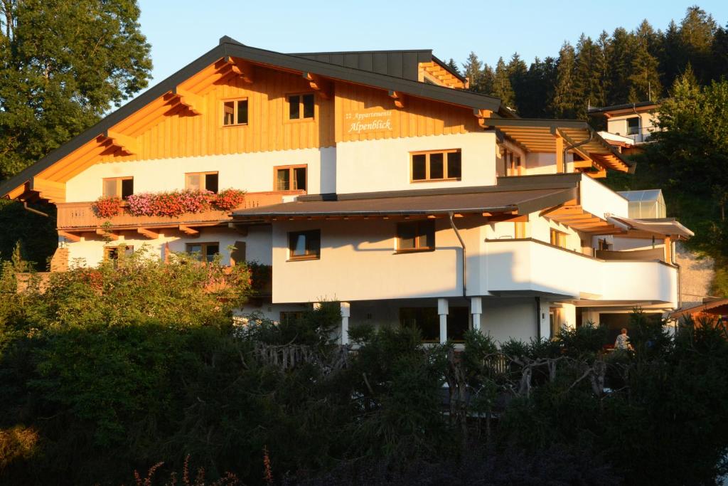 ein großes weißes Gebäude mit orangefarbenem Dach in der Unterkunft Appartements Alpenblick in Kirchberg in Tirol