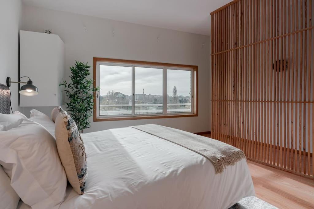 ein Schlafzimmer mit einem großen Bett und einem Fenster in der Unterkunft Modern studio near Metro Station in Senhora da Hora