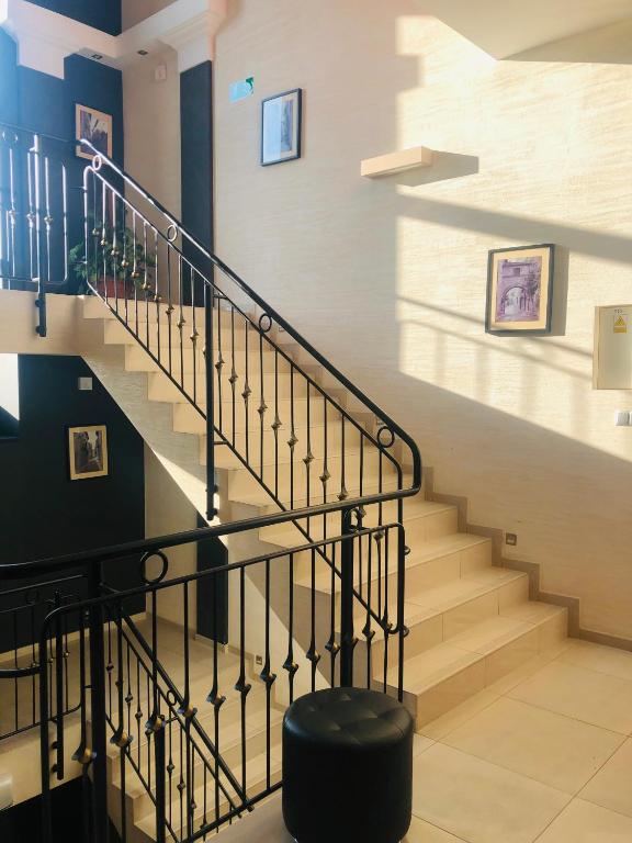 a staircase in a house with a black ottoman at Pensjonat Trzy Stawy in Jelcz