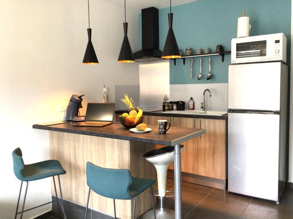 a kitchen with a counter with a laptop on it at Charmant pied-à-terre coeur de ville in Pointe-à-Pitre