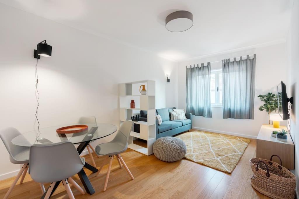uma sala de estar com uma mesa e um sofá azul em Central 2bed apt in Matosinhos em Matosinhos