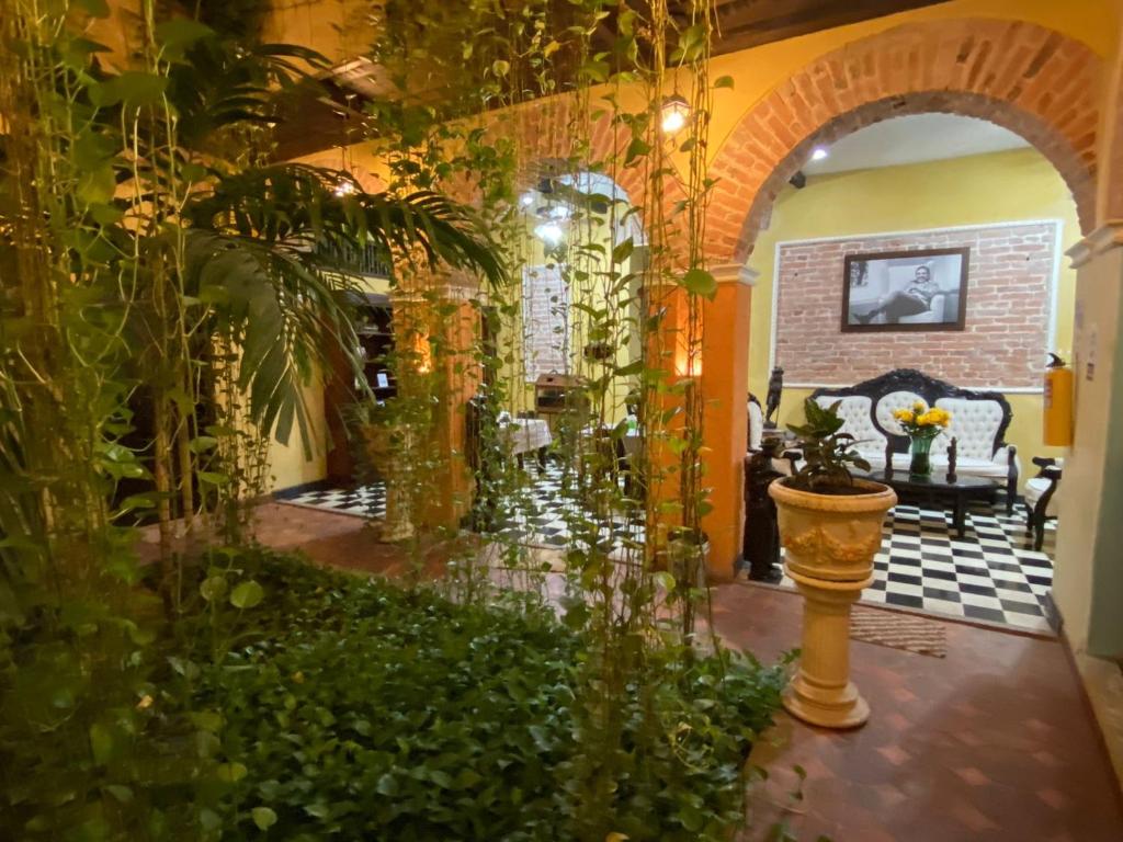 una sala de estar con un arco y plantas en hotel san nicolas colonial, en Barranquilla