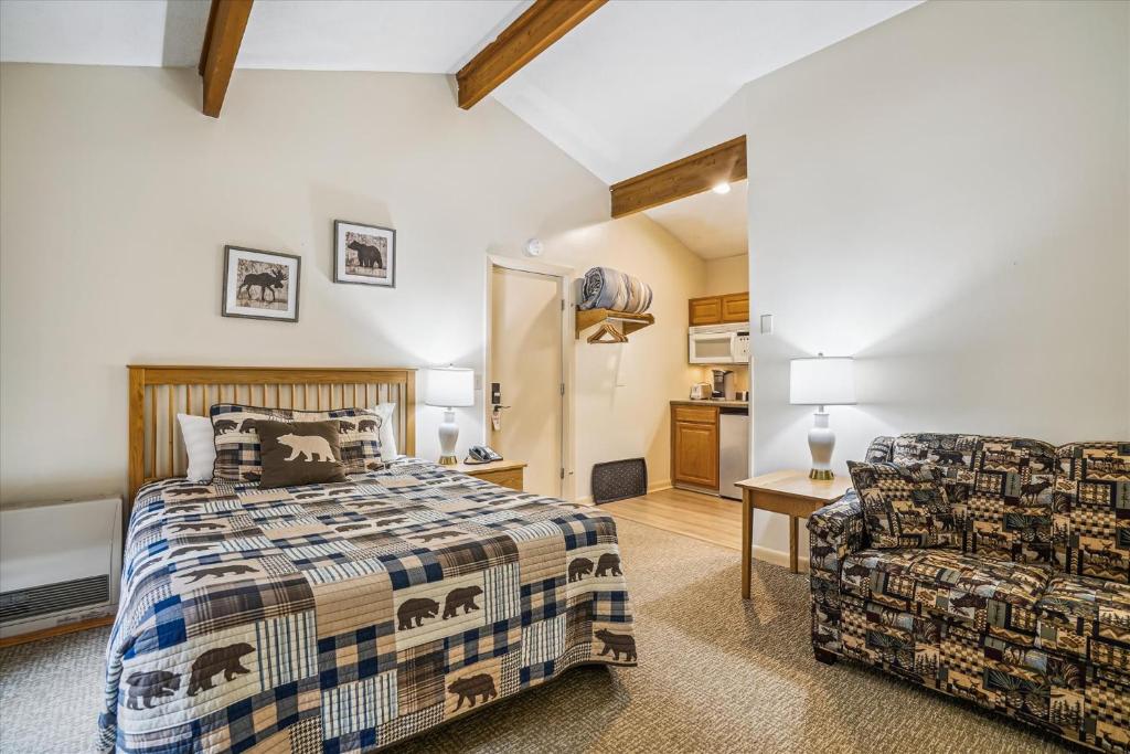 a bedroom with a bed and a chair at Cedarbrook Queen Studio 210 in Killington