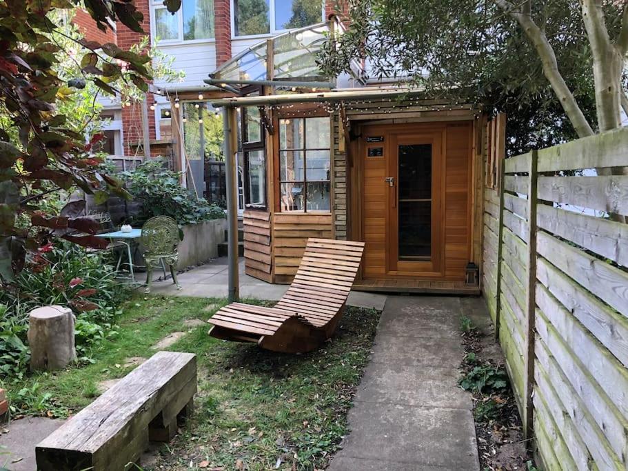 a wooden cabin with two benches in a yard at Tiny hideaway in Cambridge in Cambridge
