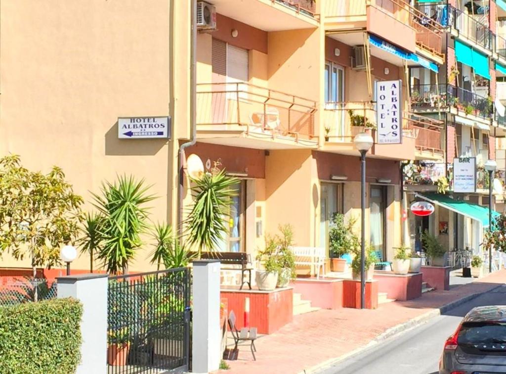 un edificio con plantas al lado de una calle en Albergo Albatros, en Pietra Ligure