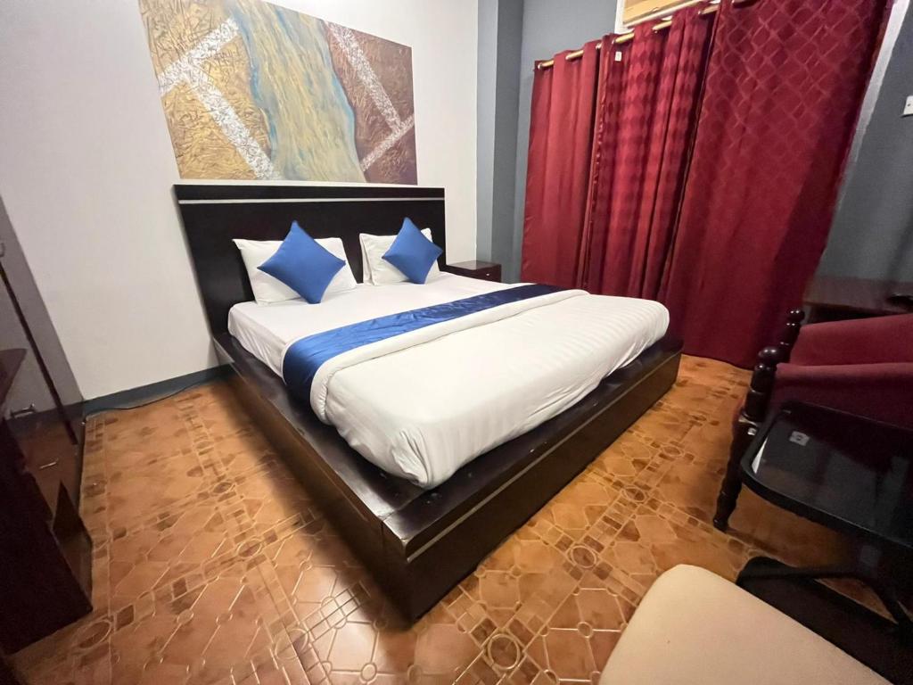 a bedroom with a large bed with blue pillows at Bab Al Bahrain Hotel in Manama