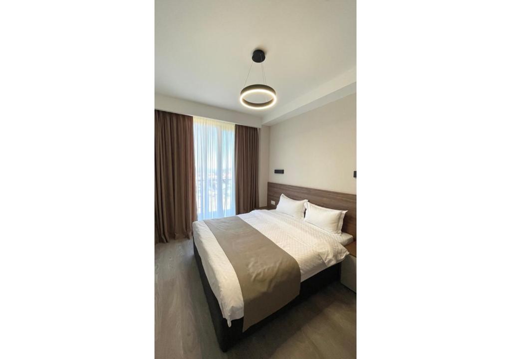 sypialnia z łóżkiem i oknem w obiekcie Crystal Loft Bakuriani - A406 w mieście Bakuriani