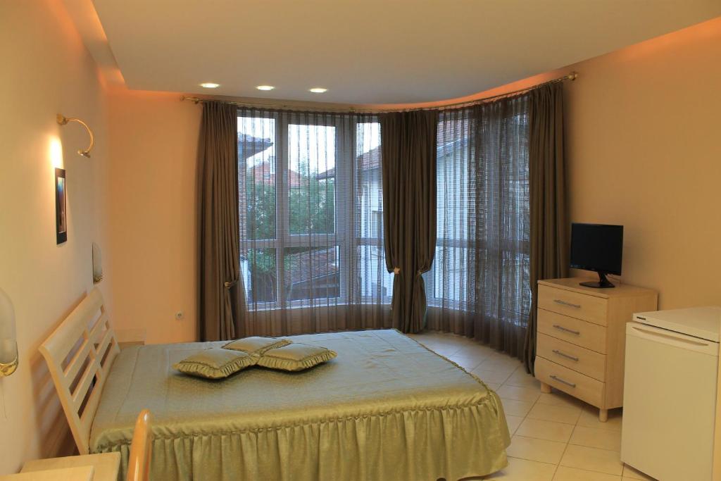 a bedroom with a bed and a large window at Stela Guest House in Tsarevo