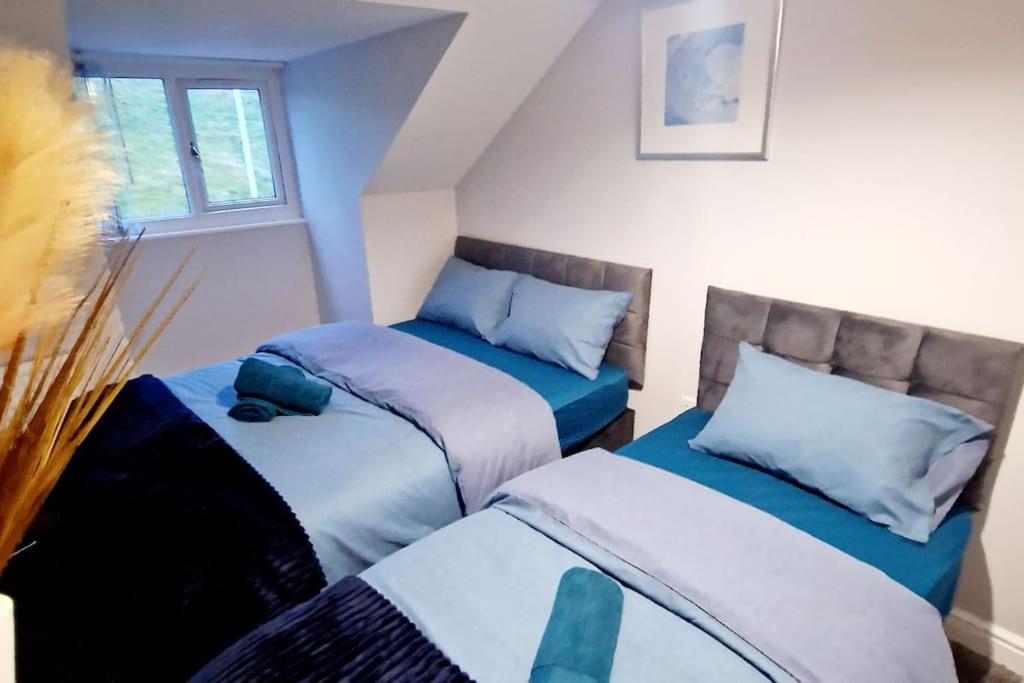 1 dormitorio con 2 camas individuales y ventana en 9 Guest 7 Beds Lovely House in Rossendale, en Newchurch