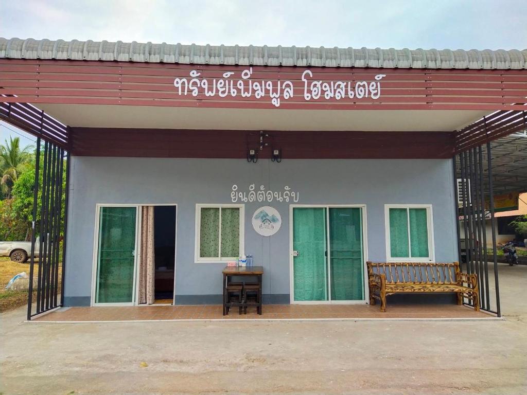 a building with a bench in front of it at Sappermpool Homestay Buengkhonglong 