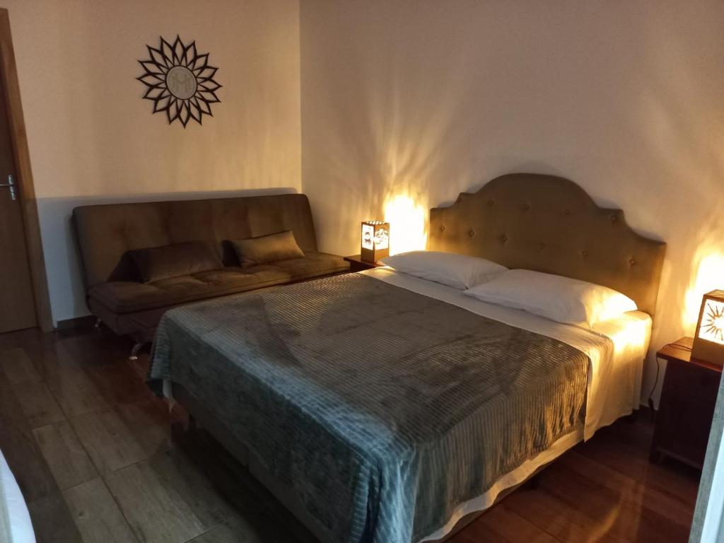 a bedroom with a large bed and a couch at Hospedaria Mitterer in Treze Tílias