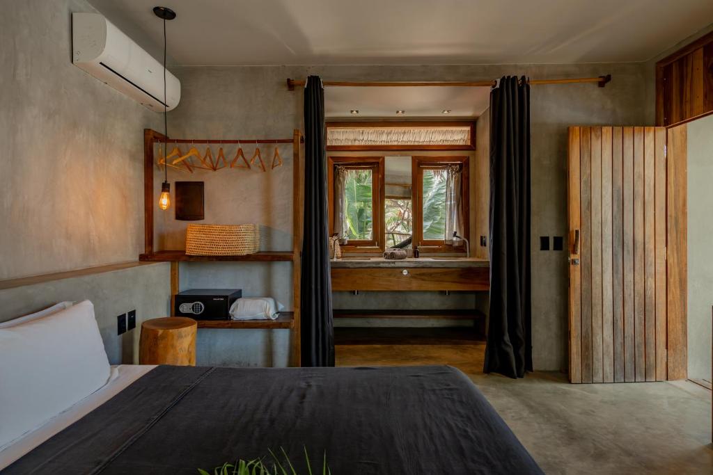a bedroom with a bed and a bathroom with a sink at Villa Mango Jeri in Jericoacoara