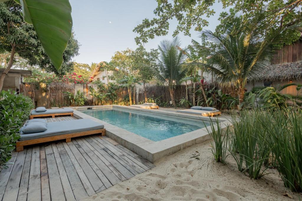 a swimming pool in a backyard with a wooden deck at Villa Mango Jeri in Jericoacoara