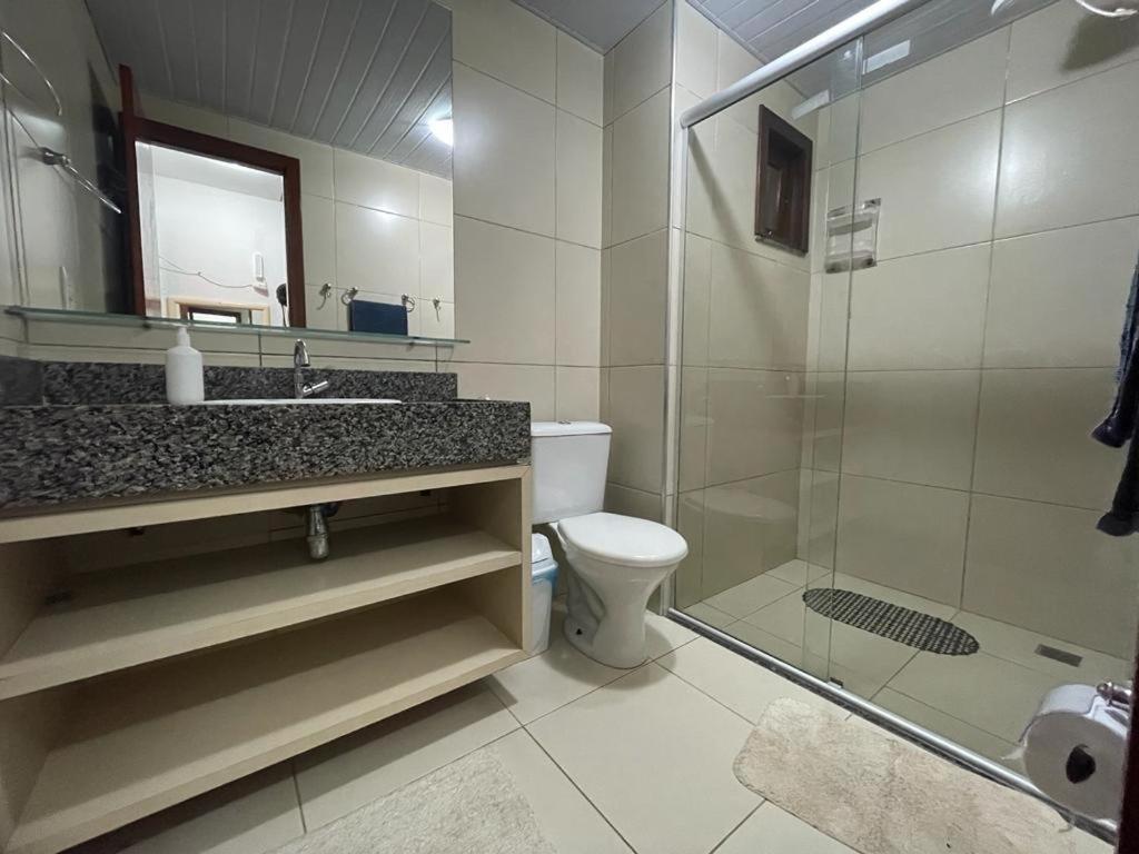 a bathroom with a shower and a toilet and a sink at Aluguel Apto. Triplex Guaramiranga. in Guaramiranga