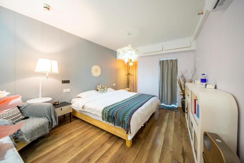 a bedroom with a large bed and a couch at 小喜屋（西湖街店） in Qingpu