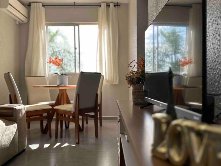 克里西烏馬的住宿－Apartamento há 5 min do Centro de Criciúma.，客厅配有桌椅和电视。