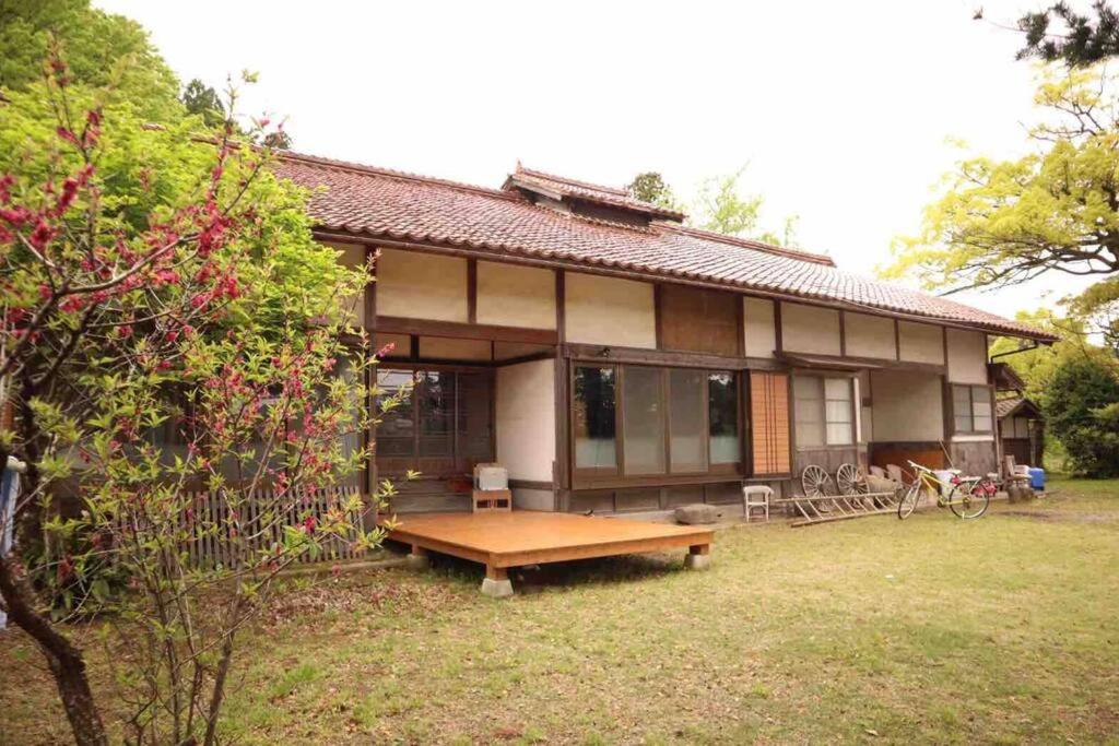 una casa con una mesa de picnic delante de ella en Private stay 120years old Japanese-style house, en Okinoshima