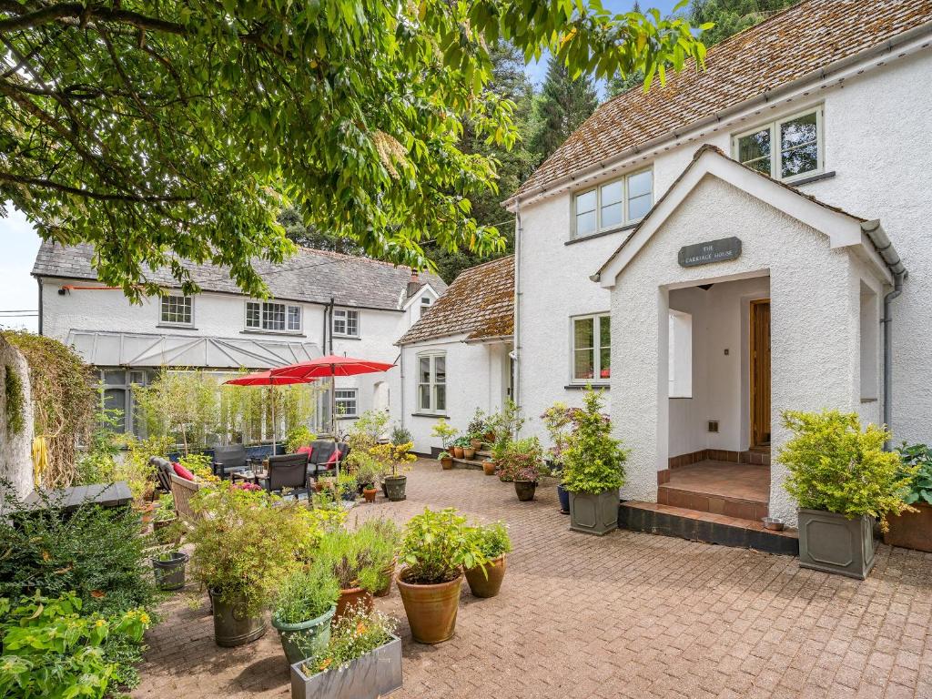 a house with a courtyard with potted plants at The Carriage House in Llanwenarth