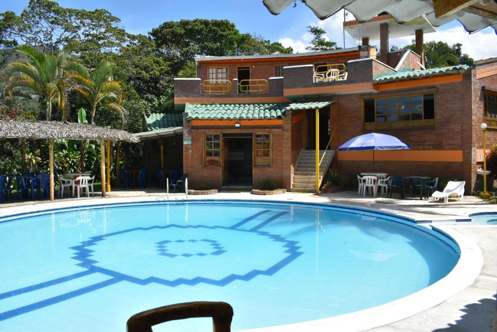 a large swimming pool in front of a house at Hotel El Bohio in Guaduas