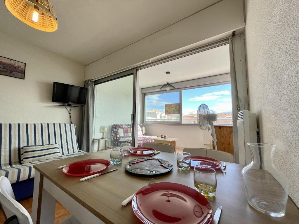 - une table à manger avec des plats rouges dans l'établissement Studio cabine avec parking à 600m des plages à Sète - FR-1-338-162, à Sète